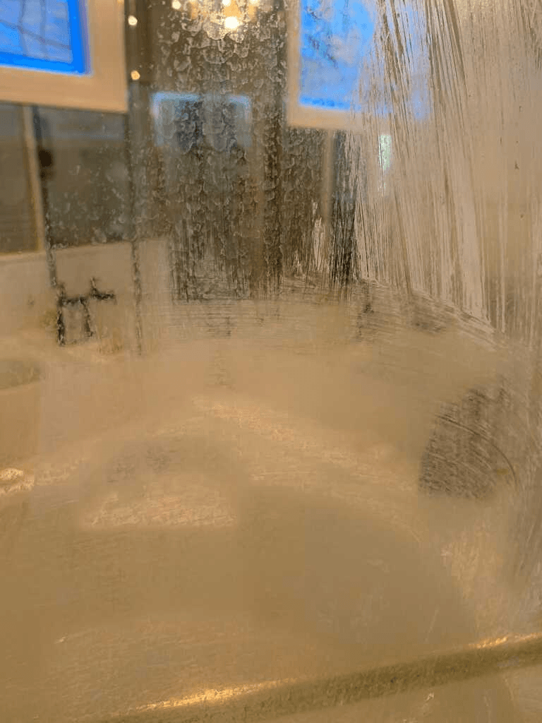 Shower glass hard water stains before house cleaning service